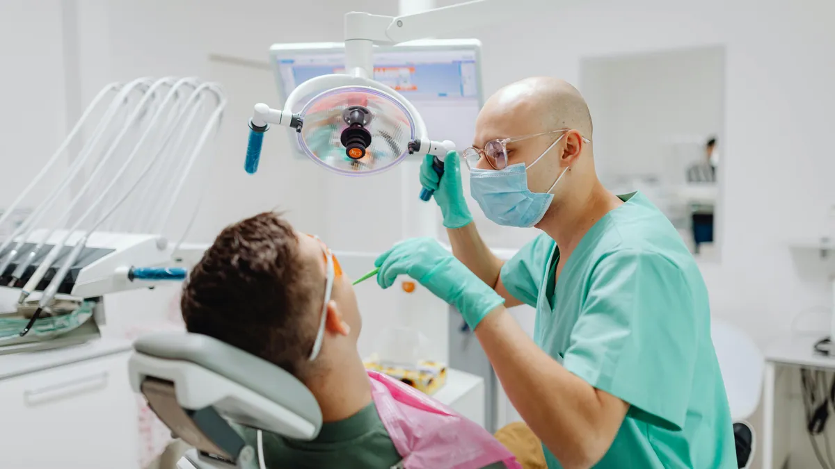 Dentist performing cosmetic dental procedure on patient in Prosper TX